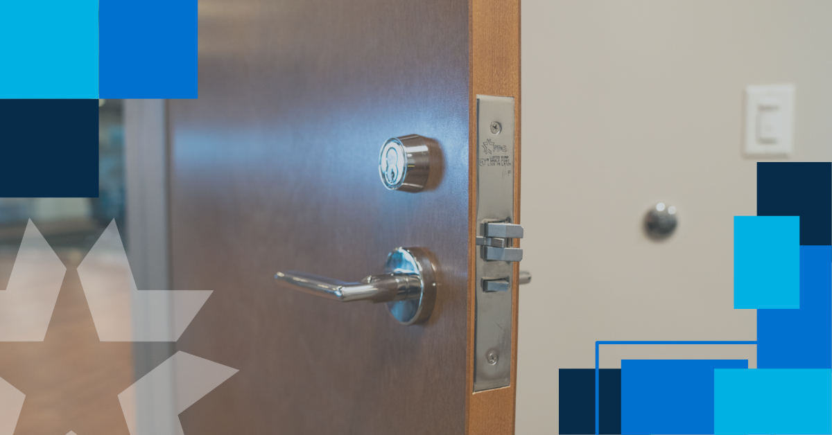 Commercial mortise lock installed in a wood door, showing the mortise cylinder above the lever handle and the mortise lock case exposed on the door edge
