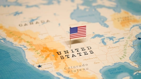 Small American flag pin marking the United States on a world map