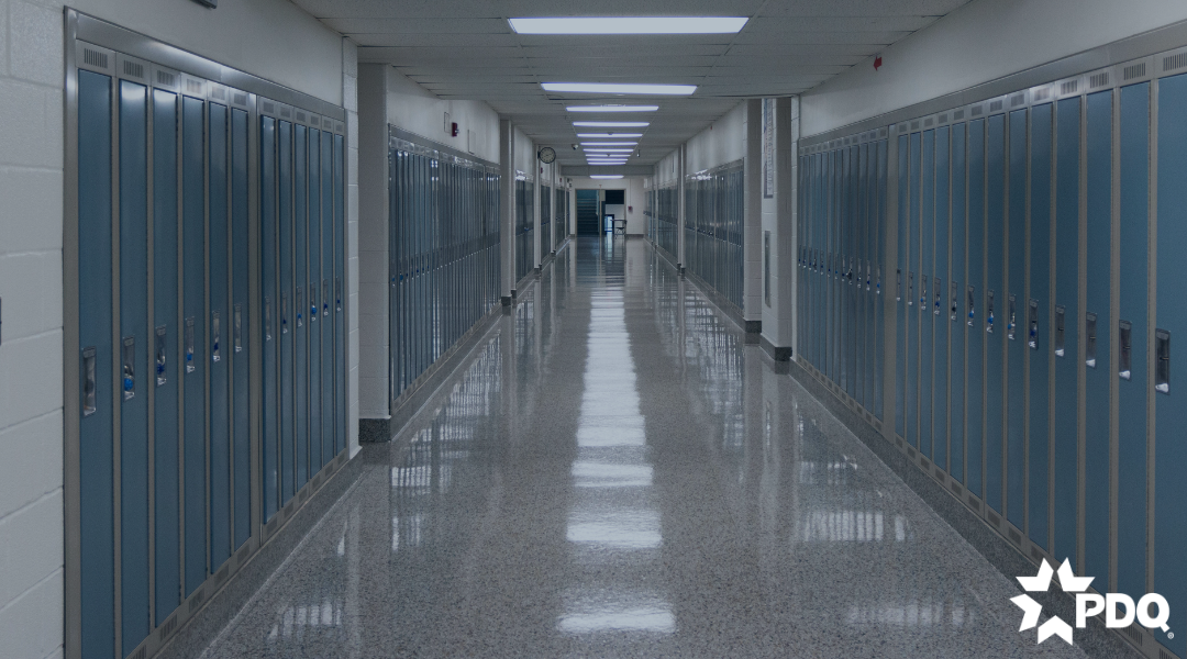 School highway with a double door exit at the end of the hallway.