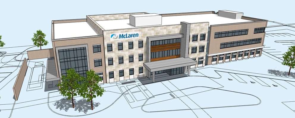 Architectural rendering of a three-story McLaren medical building with a tan and beige stone facade, glass entrance canopy, wood-accented entryway, blue McLaren logo above the entrance, surrounded by young trees and a parking lot in front.