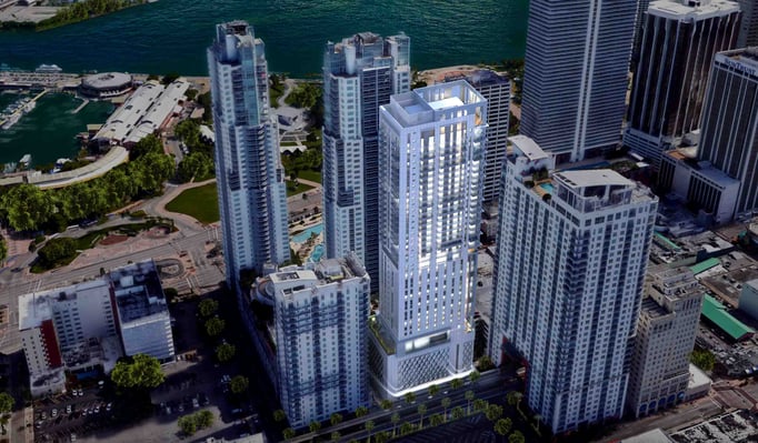 Aerial rendering of the proposed Yotel high-rise tower in downtown Miami, showing a glass-and-white paneled residential building rising among surrounding skyscrapers near the Miami River, with a decorative patterned base and rooftop terrace.