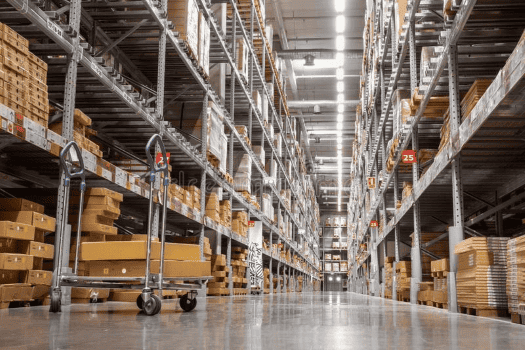 A long view of a warehouse stocked with products throughout the shelves